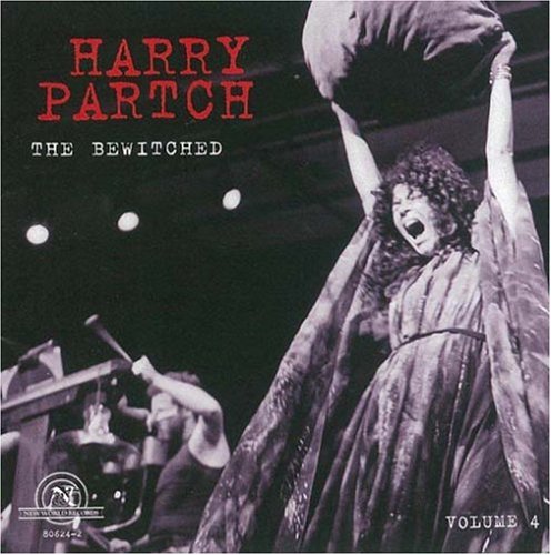 Black-and-white image of a woman on stage, with her arms raised and mouth open in song.