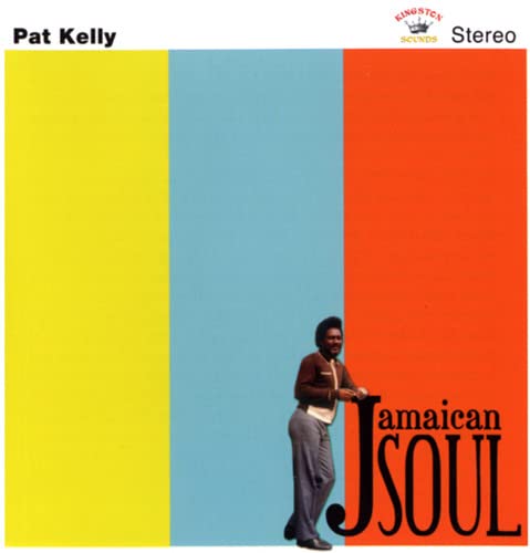 Pat Kelly standing against a background of yellow, blue, and orange vertical stripes.