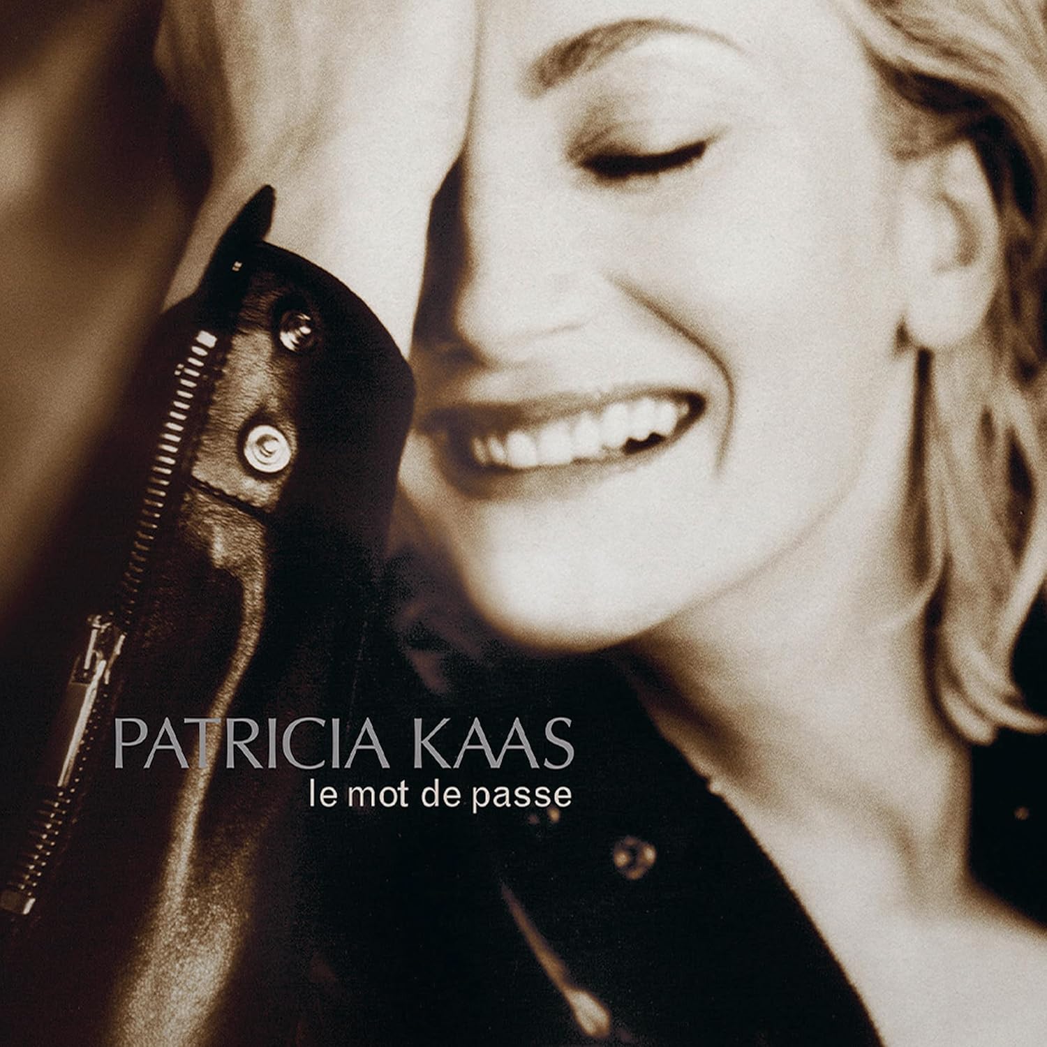 Patricia Kaas album cover, close-up of singer with microphone.
