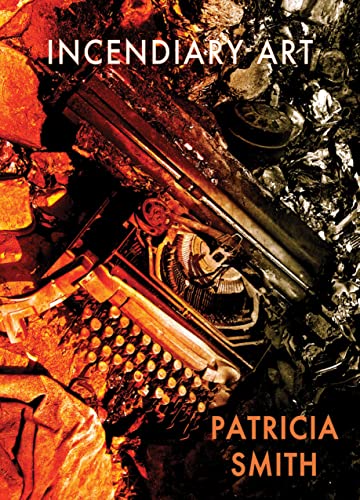A charred typewriter sits amidst glowing embers and debris on a dark background.