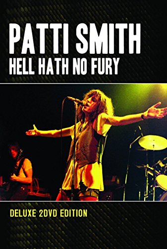 Patti Smith performing live with a microphone, concert stage background.