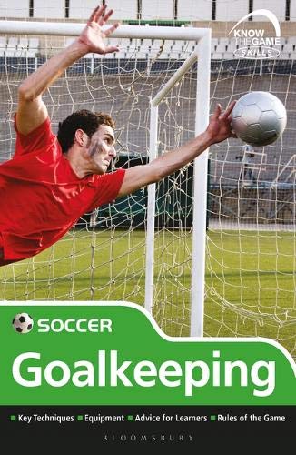 Soccer goalkeeper diving for a ball in front of the net.