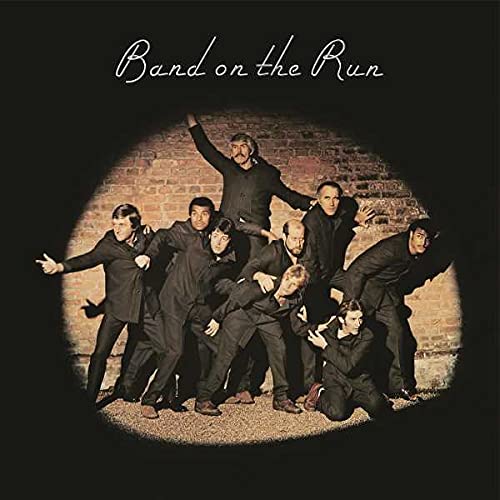 Album cover featuring Paul McCartney and Wings in a spotlight against a brick wall.