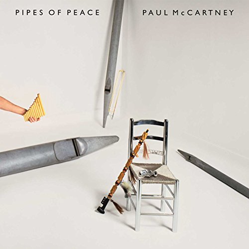 Album cover showing a hand holding pan pipes, organ pipes, and a chair.