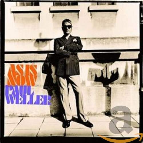 Paul Weller album cover, "As Is Now," featuring a suited man posing.