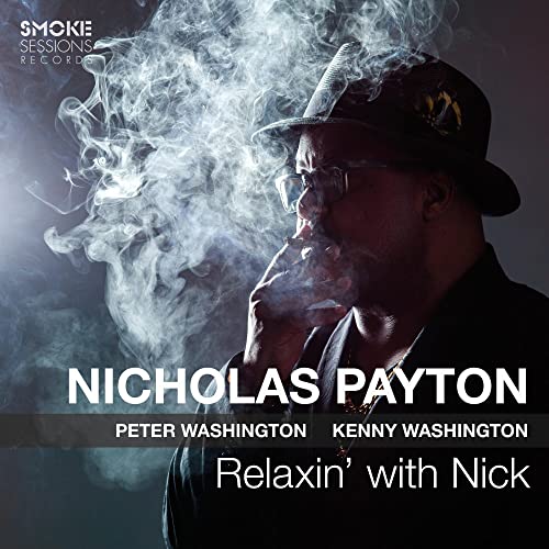 A man in a hat smokes a cigarette in this album cover portrait.