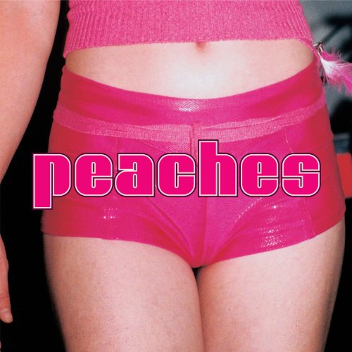 A person wearing a pink crop top and shiny pink shorts with peaches text overlay.