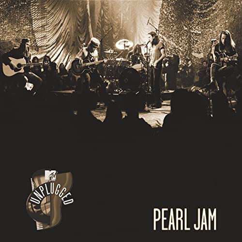 Pearl Jam performing live with instruments on a dimly lit stage.