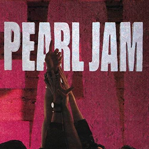 Pearl Jam logo over a pink brick wall with hands raised in the foreground.