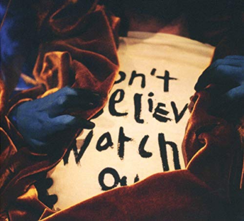Hands holding a CD case with handwritten text: “Don’t Believe, Watch Out.”
