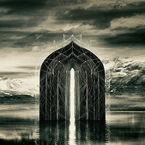 Dark, geometric archway against a mountainous, cloudy landscape.