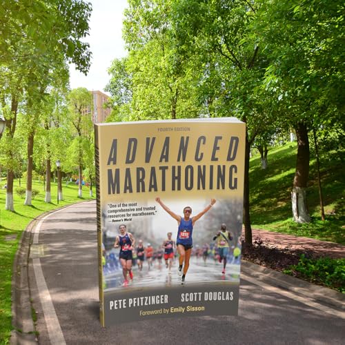 The book Advanced Marathoning by Pfitzinger and Douglas stands on a park path.