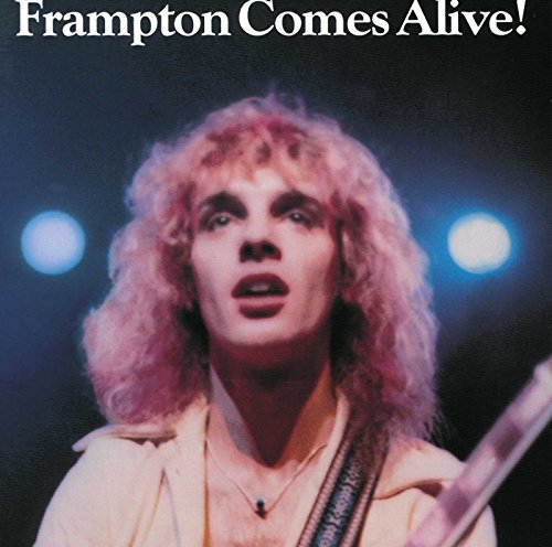 Peter Frampton with long curly hair performing on stage under blue spotlights.