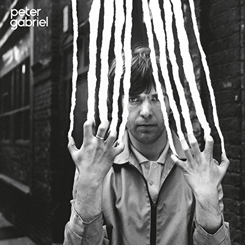 Black and white album cover featuring Peter Gabriel with tearing strips.