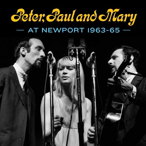 Black and white photo of Peter, Paul and Mary performing with microphones.