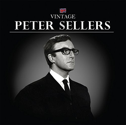 Black and white portrait of Peter Sellers in suit and glasses.