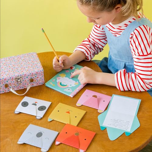 Child writing in journal with animal-shaped notecards and craft kit.