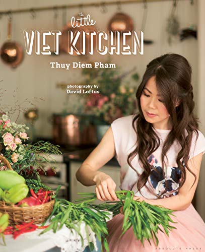 "Cookbook cover featuring a woman preparing vegetables in a kitchen, with title and author."