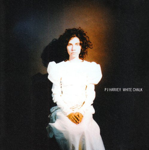 PJ Harvey album cover: woman in white dress, dark background.