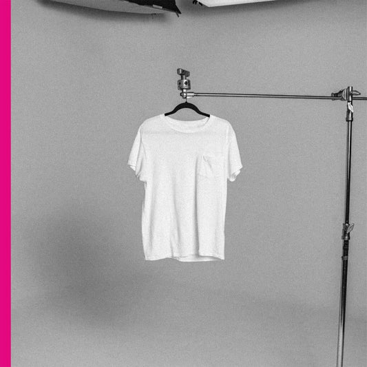 Black and white photo of a white t-shirt hanging on a stand.