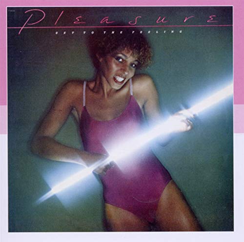 A woman in a magenta leotard holds a glowing light tube against a dark background.