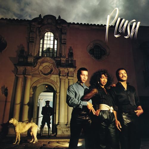 Album cover for “Plush” featuring three people and a dog in front of a building.