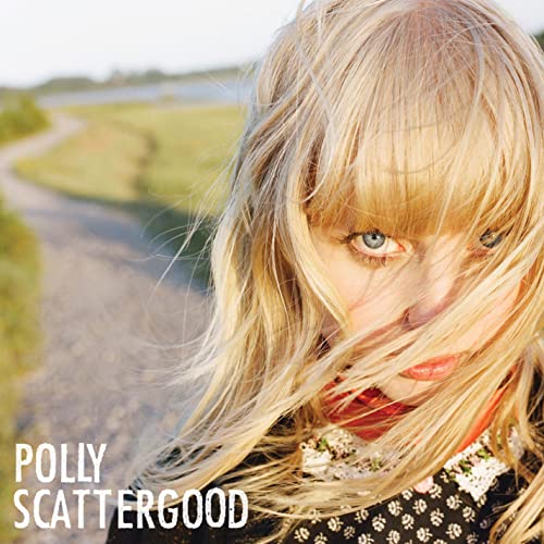 Close-up portrait of Polly Scattergood with blonde hair and a rural background.