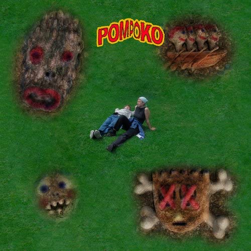 Man lying on grassL green grass surrounded by surreal, distorted faces emerging from ground.
