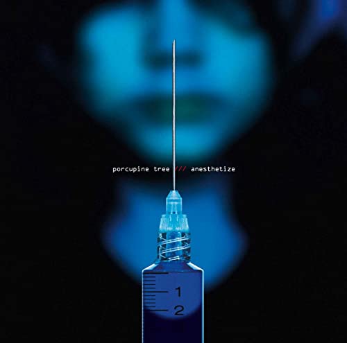 A hypodermic needle centered against a blurred blue face on a black background.