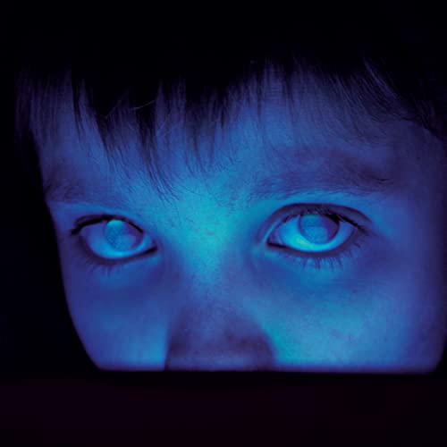 Close-up of a child's face with blue-tinted eyes and dark surroundings.