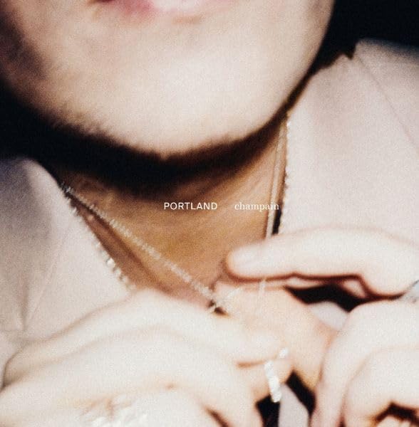 Close-up of a person’s neck and hands with album title overlayed.