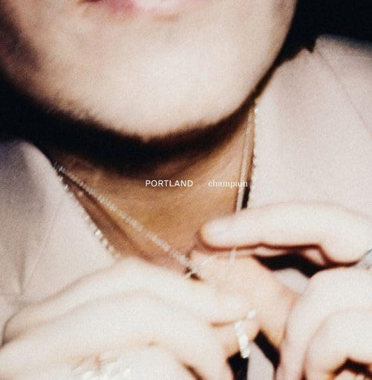 Close-up of a person’s neck and hands with album title overlayed.