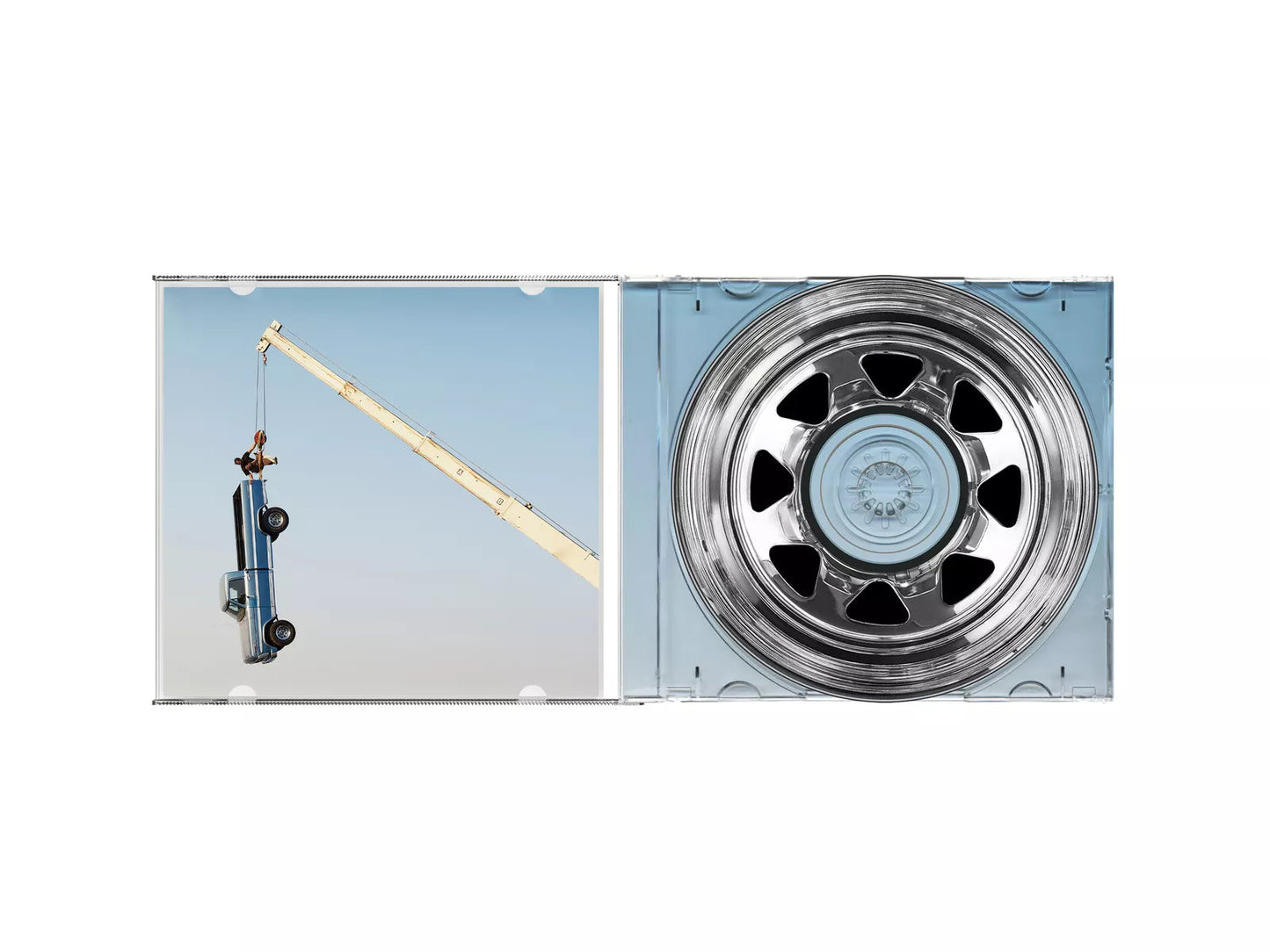 Open CD case showing a crane lifting a truck and a chrome wheel hub.