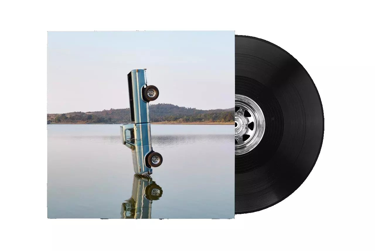 Vinyl record cover featuring a truck standing vertically in a lake next to disc.