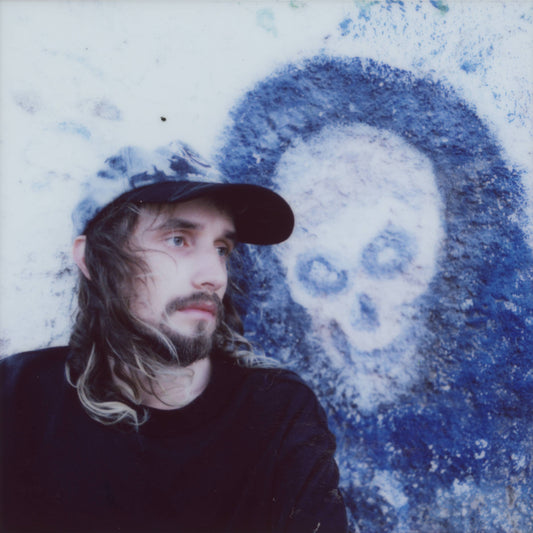 Pouya album cover: man with long hair and skull graffiti.