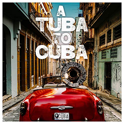 Red convertible with a tuba, Cuban street scene background.