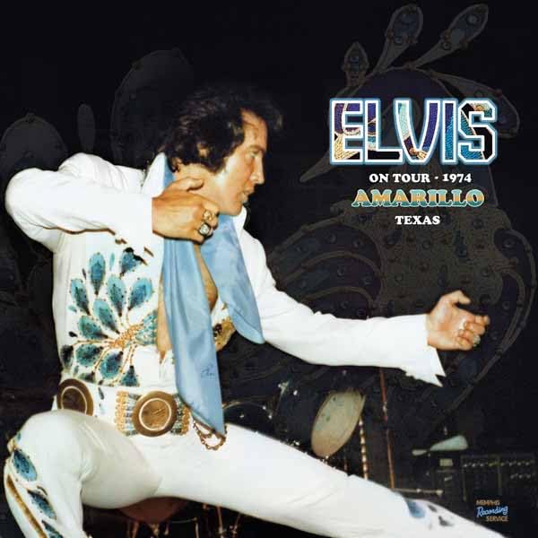 Elvis Presley in a white jumpsuit performing on stage in 1974.
