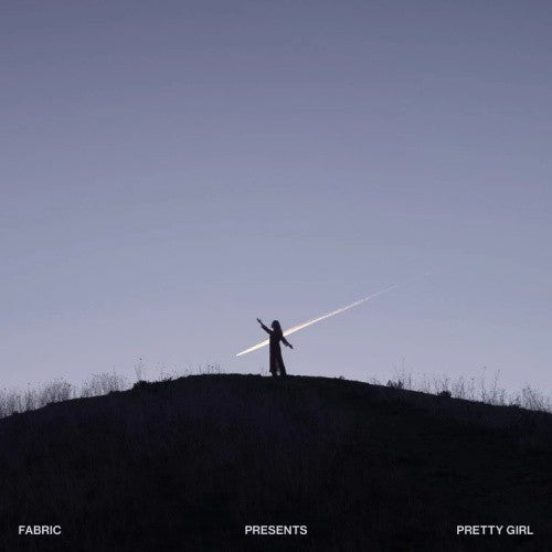 Silhouette of a person on a hill with a light beam above.