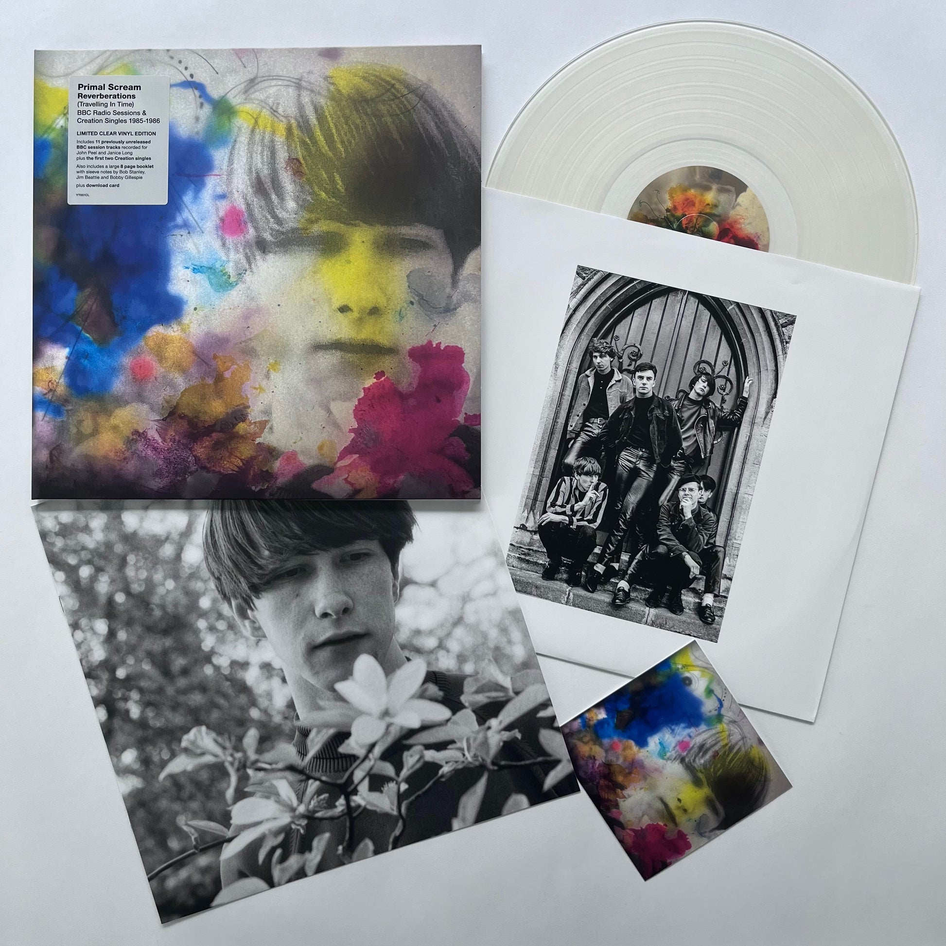 "Clear vinyl record with album cover and booklet featuring black and white and colorful images."