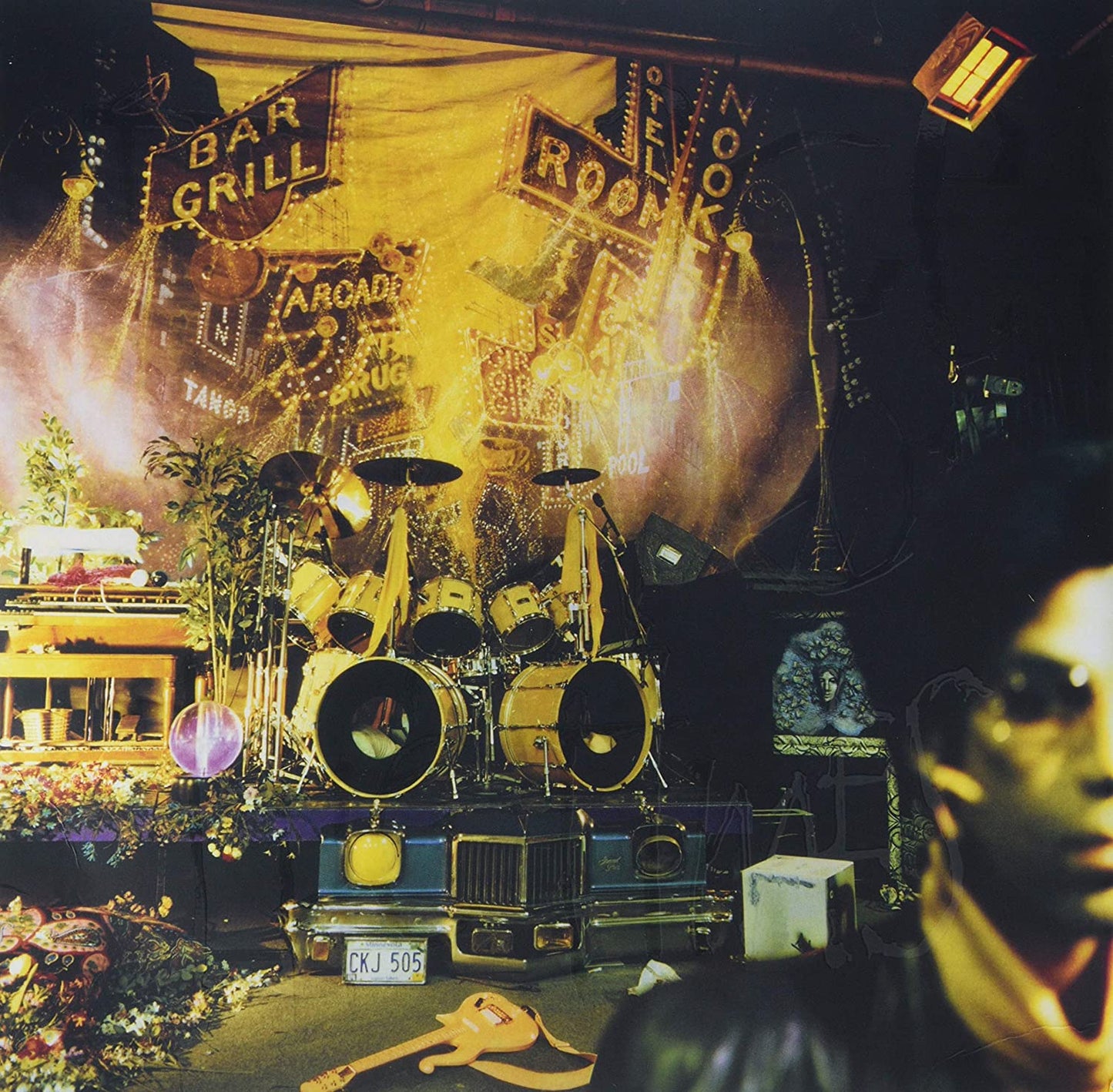 "Album cover with a man in front of a stage with drums."