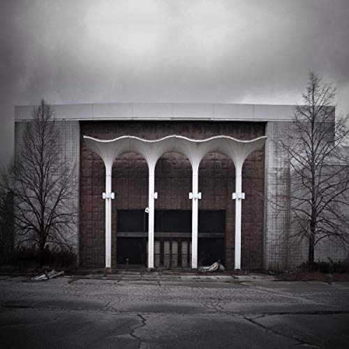 Black and white photo of a large, arched building facade.