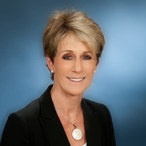 Headshot of a woman with short blonde hair, smiling and wearing a blazer.