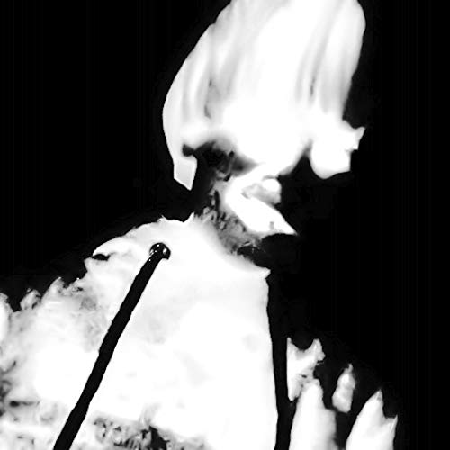 Black and white image of a person’s face obscured by smoke and flames.