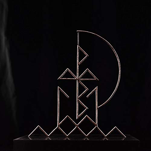 The image shows a gold wire sculpture on a black surface against a black background.