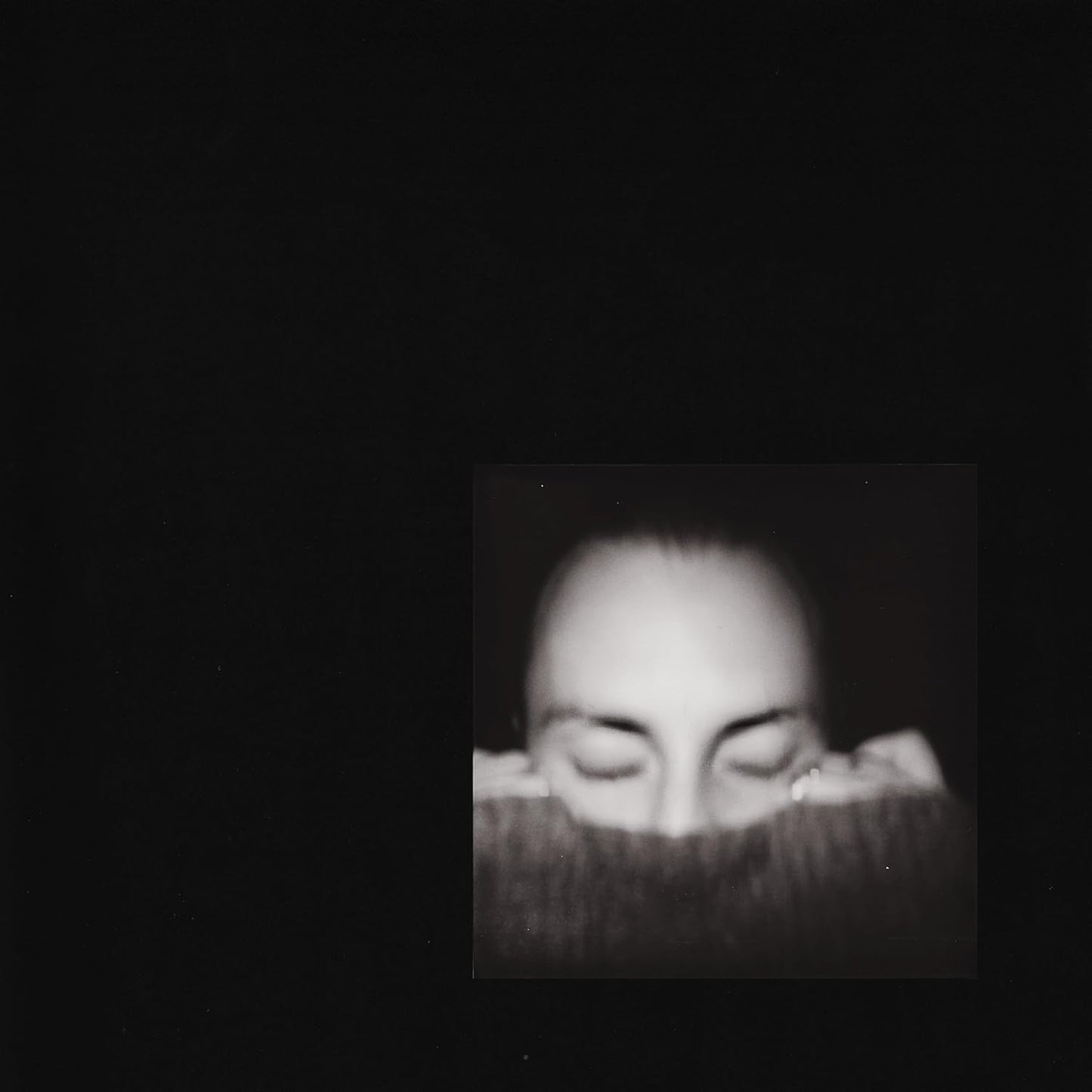 Black and white portrait of a person with closed eyes, vinyl record art.