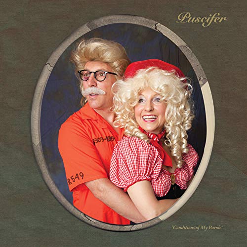 A man in an orange prison jumpsuit hugging a woman in a red outfit.
