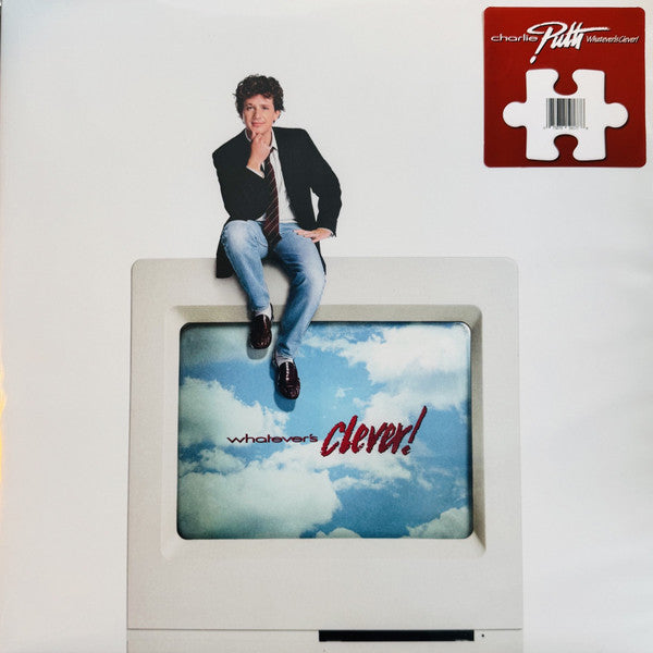 Charlie Puth sitting on a computer monitor displaying a blue sky with clouds.