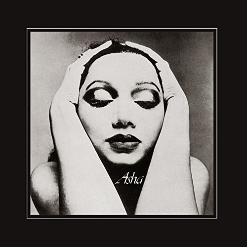 Black and white portrait of Asha Puthli with hands framing her face.