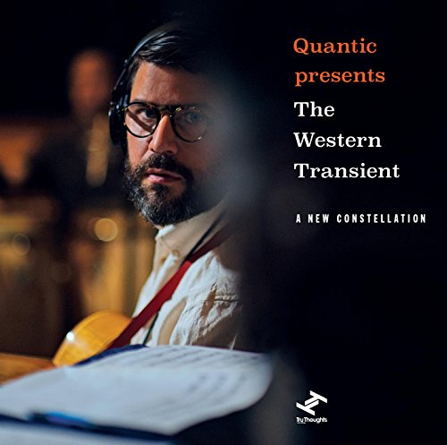 Album cover featuring a man with glasses and headphones, dark background.