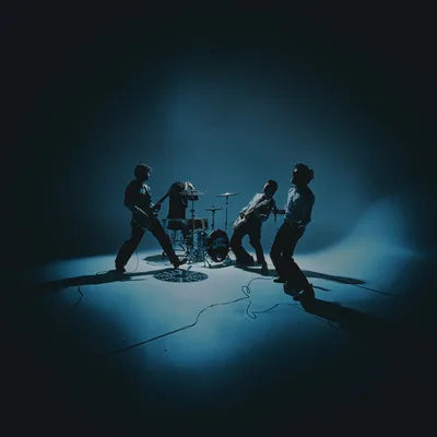Four musicians performing with instruments in a dimly lit room.
